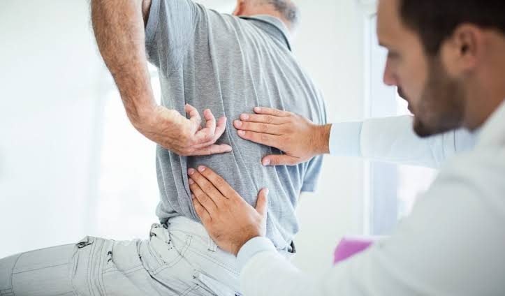 Pain specialist examining a patient with back pain at Pain Clinic of India
