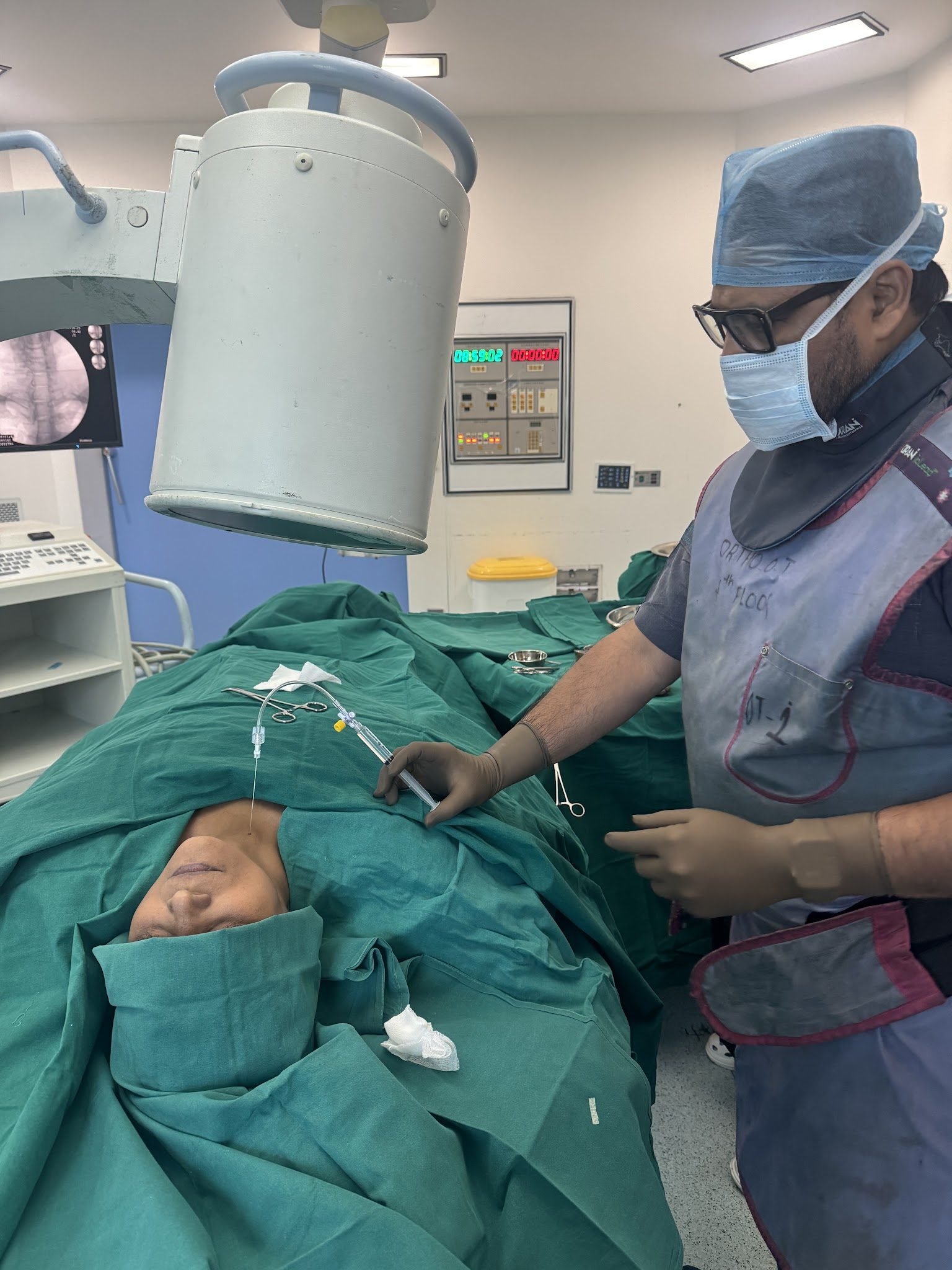 Pain specialist performing a spine procedure using a C-arm imaging system